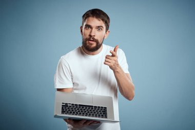 Mavi arkaplanda dizüstü bilgisayarı olan duygusal adam klavye internet modeli kırpılmış görünüm