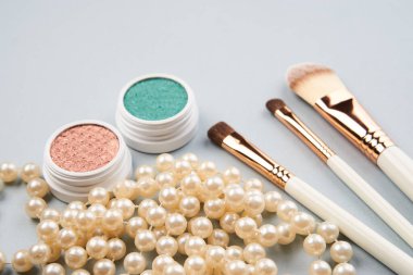 Göz makyajı fırçaları, gri arkaplandaki profesyonel kozmetik aksesuarları koleksiyonu.