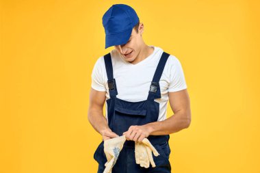 Çalışan üniformalı bir adam servis servisi sarı arka planını sunuyor.