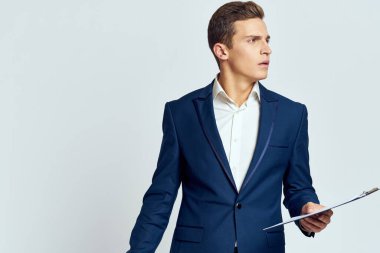 Kendine güvenen bir takım elbiseli bir iş adamı ve hafif bir arkaplanı tanıyor.