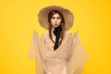 Sarı arka planda kırmızı örgülü kadın portresi.