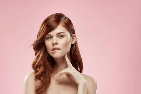 Bella donna con lunghi bei capelli toelettatura acconciatura glamour spalle nude sfondo rosa — Foto Stock