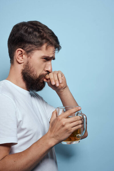 Bearded man beer mug alcohol white t-shirt side view blue background