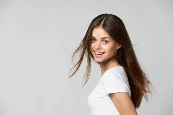 Glimlachende vrouw met los haar naar voren leunend en wit T-shirt — Stockfoto