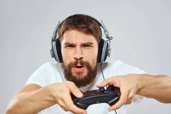 Hombre en auriculares con gamepad jugando hobby entretenimiento estilo de vida luz fondo —  Fotos de Stock