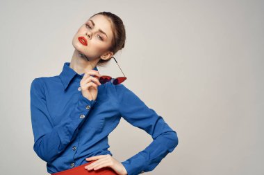 Güneş gözlüklü bir kadın portresi ve arka planda mavi bir gömlek. Model Kopya Boşluğu görünümü.