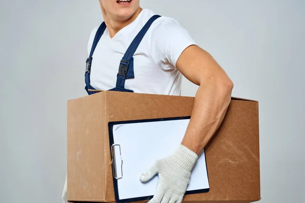 Homem trabalhador com caixa em mãos entrega carregamento serviço luz de trabalho fundo — Fotografia de Stock