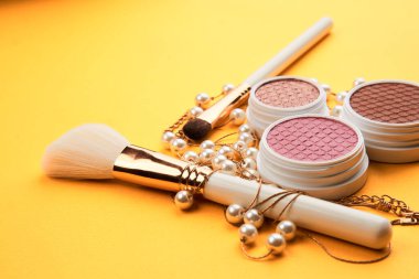 Sarı arka plandaki göz falı profesyonel makyaj makyaj fırçası yumuşak sünger moda gözlükleri