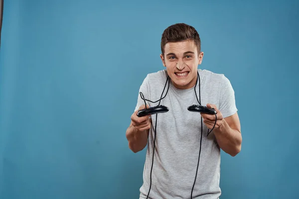 Hombre con joysticks cables tecnología juegos entretenimiento diversión fondo azul —  Fotos de Stock