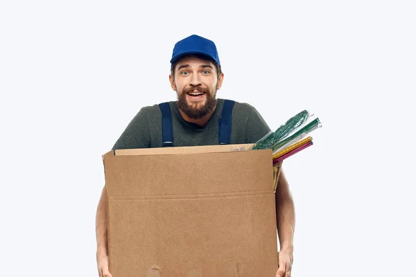 Egy munkaruhás férfi dobozzal a kezében szállítási munka. — Stock Fotó
