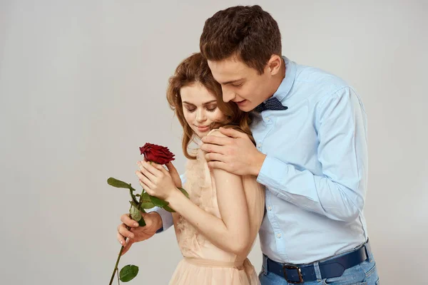 Milenci muži a žena objetí romantika láska červená růže světlo pozadí — Stock fotografie