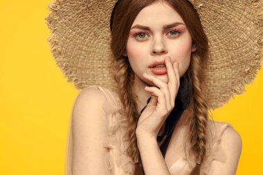 Sarı arka planda saman şapkalı portre kadın. Yazlık elbise mankeni romantizmi.