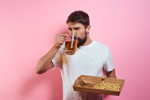 Man met dienblad van fast food en mok bier frietjes fast food bijgesneden uitzicht — Stockfoto