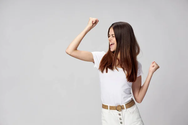 Енергетична жінка в білій футболці зі згорнутими руками в кулачкові емоції — стокове фото