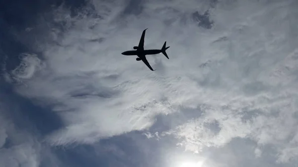 Mavi gökyüzünde bulutlar arasında son derece düzlemde. Seyahat