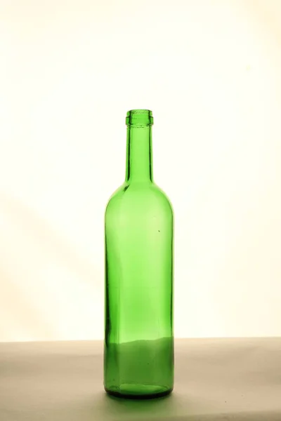 Yeşil şişe boş bir masaya şeffaf bir arka plan olduğunu.