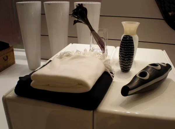 Banyoda iç. Yumuşak beyaz ve siyah havlu bir başucundaki ve bir vazo çiçekleri ile azaltılmış