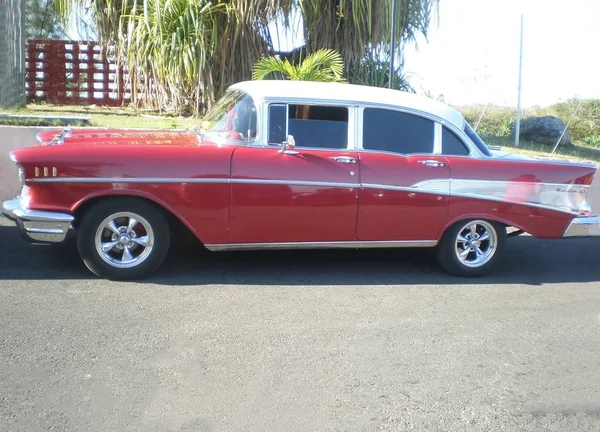 Yaz aylarında sıralar asfalt yolu üzerindeki eski klasik yabancı araba kırmızı renk, retro jotas araba.