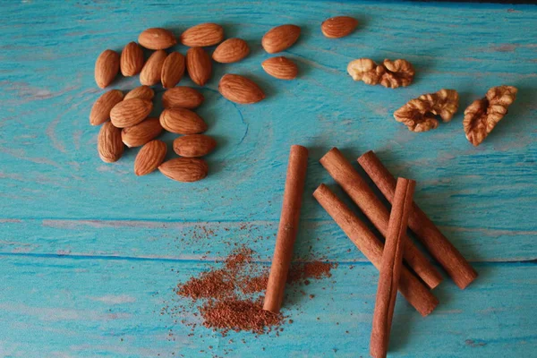 Tarçın, ceviz ve badem üzerinde bir açık mavi renkli shabby chic natürmort. Bir kahve töreni için lezzetli menü. Yatay fotoğraf.