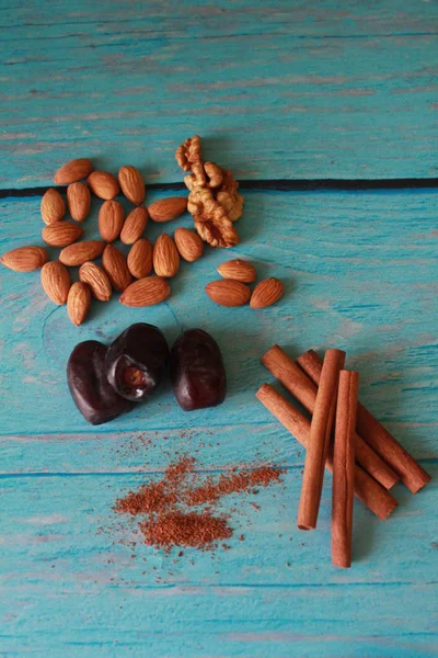 Natürmort üç tarihlerinin, ayrıca dağılmış, tarçın badem fındık üzerinde bir açık mavi renkli bir stilin Shabby chic çok. Dikey fotoğraf. Lezzetli menü Cafe, kahve için malzemeler için.