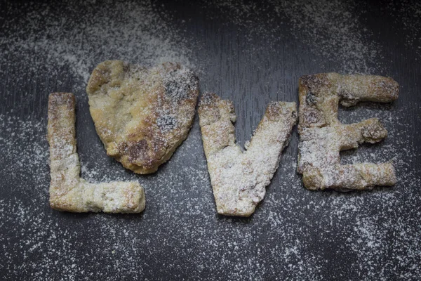 Kuru üzüm karanlık bir tablo ile kendi el ile yapılan ev yapımı kurabiye un serpilir. Aşk testi gelen mektuplar. Yatay fotoğraf-ebilmek var olmak kullanılmış bir web tasarımı, menü, takvimler için.