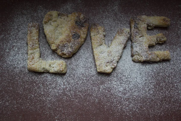 Kırmızı bir arka plan üzerinde kendi elleri ile yapılmış kurabiye un serpilir. Aşk testi gelen mektuplar. Bu kullanılabilir bir web tasarımı, belgili tanımlık yemek listesi, takvim.