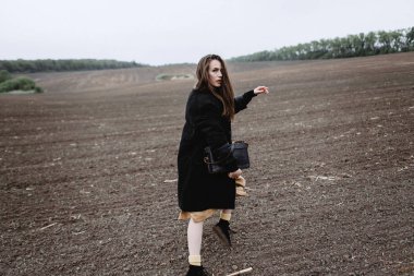 Kadın modeli rüzgarlı hava sahasındaki poz, arkadan görünüş