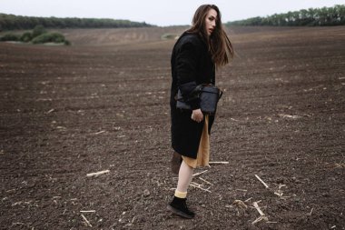 Kadın modeli rüzgarlı hava sahasındaki poz, arkadan görünüş