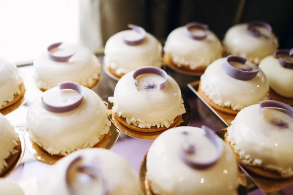 Closeup of festive glazed cakes on glass tray