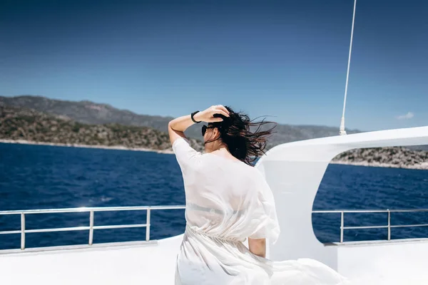 Slim woman in black bikini enjoying time on yacht