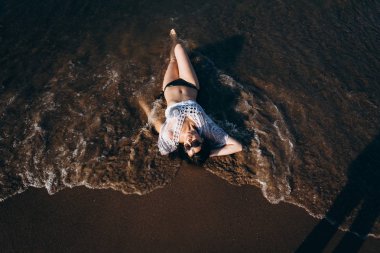 Güneş gözlüğü ve ıslak sahil üzerinde döşeme bikini içinde kadın üstten görünüm