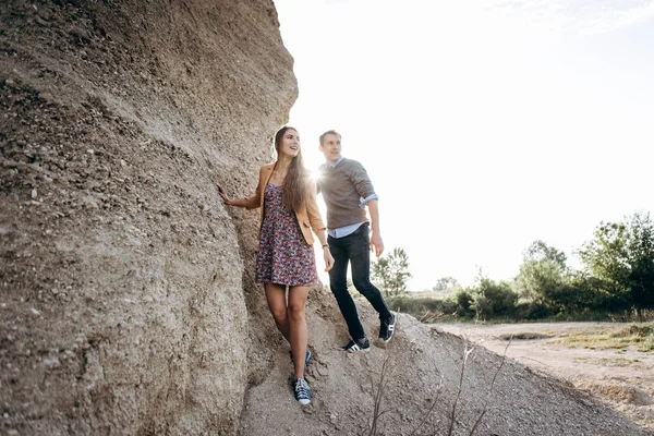 素敵なカップルが一緒に崖の麓を歩く — ストック写真