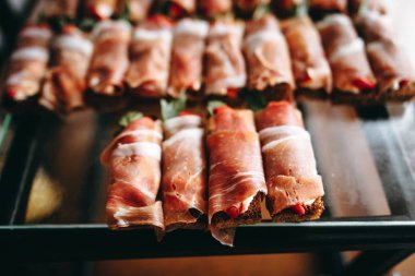 Siyah ekmek, salam, kurutulmuş domates ve roka yapılmış rulo