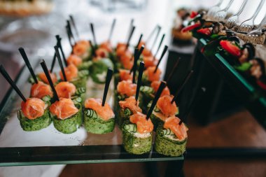 Meze cattering - somon ve kabak Sis kebap, patlıcan rools camına çatal ile standları.