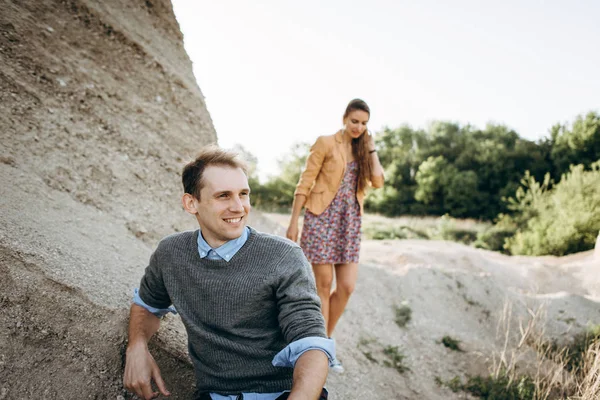 Lovely couple walking together at foot of cliff