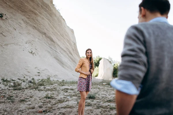 Lovely couple walking together at foot of cliff