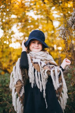 Kız panço ve şapka sonbahar ormanda yürüyüş