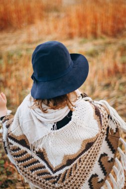 Sonbahar alanı tarafından yürümek poncho kızın arkadan görünüş