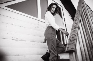 Kadın gömlek ve pantolon ahşap çardak merdivenlerde poz