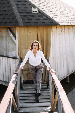 Şık kadın gömlek ve pantolon ahşap çardak poz