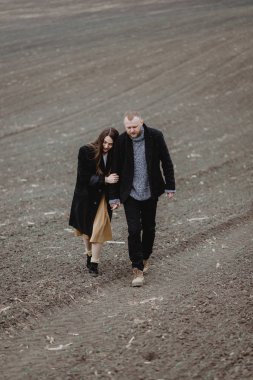 Kasvetli bir günde birlikte yürüyen genç bir çift.