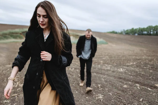 Üzgün kadın ve adam tarlada yürüyor.