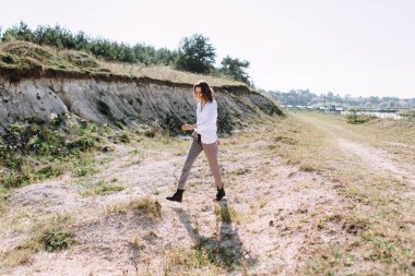 Dalgalı saç modeli ile açık havada yürüyüş güzel kadın modelyan görünümü