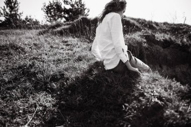 Açık havada poz veren gündelik kıyafetler içinde kadın modelin siyah beyaz portresi