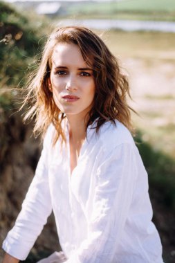 Çıplak makyajlı ve dalgalı saç stili olan bir kadın.