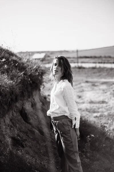 Black and white portrait of female model in casual clothes posing outdoors