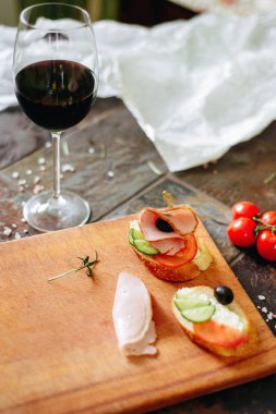 Philadelphia peynir, jambon, salatalık ve domates ile bruschettas kırmızı şarap ile servis.