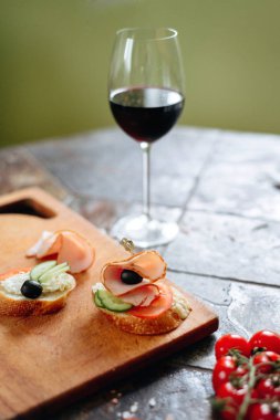 Philadelphia peynir, jambon, salatalık ve domates ile bruschettas kırmızı şarap ile servis.