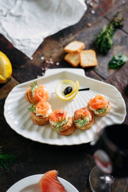 Somon ile puf pasta meze, Philadelphia peynir ve beyaz deniz kabuğu plaka üzerinde dereotu kırmızı şarap ile servis.