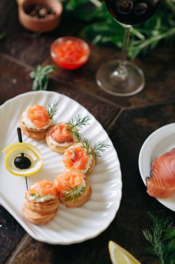 Somon ile puf pasta meze, Philadelphia peynir ve beyaz deniz kabuğu plaka üzerinde dereotu kırmızı şarap ile servis.
